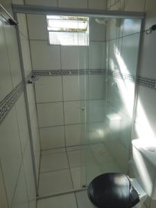 uma casa de banho com uma cabina de duche em vidro e um WC. em Sítio Iracema em Porto Alegre