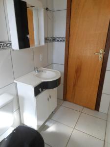 uma casa de banho com um lavatório e uma porta de madeira em Sítio Iracema em Porto Alegre