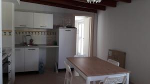 - une cuisine avec une table en bois et des placards blancs dans l'établissement ALLOGGI DEL SOLE, à Polignano a Mare