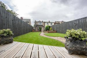 a backyard with a fence and two potted plants on a wooden deck at Moor Cottage, Attractive 3 bed with Garden Bishop Auckland KYNREN in Low Etherley