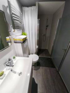 y baño con lavabo blanco y ducha. en Big Apartment - City Center - 70m2 - Nice Design, en Wroclaw