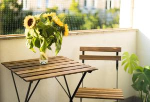 een vaas met zonnebloemen op een houten tafel bij Big Apartment - City Center - 70m2 - Nice Design in Wrocław