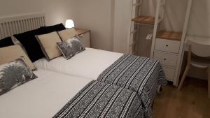 a bedroom with a white bed with pillows and a desk at Belle Egia - Free Parking in San Sebastián