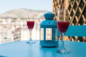 zwei Gläser Rotwein und eine Laterne auf dem Tisch. in der Unterkunft Attico Oltremare B&B in Neapel
