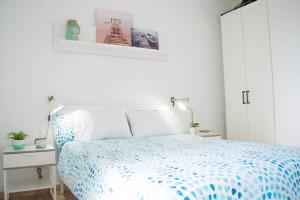 a bedroom with a bed with a blue and white comforter at Steps to the beach!!! in Santa Cruz de Tenerife