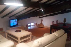 salon z kanapą, telewizorem i stołem w obiekcie Acogedor ático vacaciones cerca de BILBAO, BEC w mieście Barakaldo