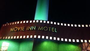 um edifício verde com um movimento Um sinal de modelo. em Movie Inn Motel e Hospedagem em Ribeirão Preto
