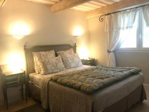 1 dormitorio con 1 cama con 2 lámparas y una ventana en Domaine Lafayette, en Loriol-du-Comtat