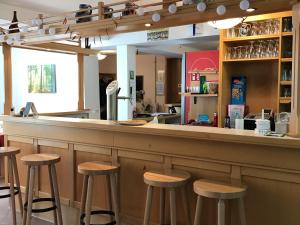 um bar com bancos de madeira num restaurante em Alte Schule Niederdünzebach em Eschwege