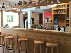 un bar con taburetes de madera en un restaurante en Alte Schule Niederdünzebach, en Eschwege