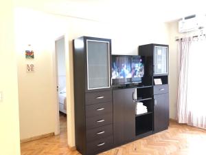 a living room with a tv and a dresser with a television at Corazón de Recoleta in Buenos Aires