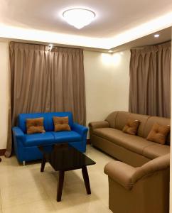 a living room with two couches and a coffee table at Arcadio's Guest House in Mactan, Cebu in Cebu City