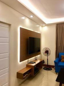 uma sala de estar com uma televisão de ecrã plano na parede em Arcadio's Guest House in Mactan, Cebu em Cebu