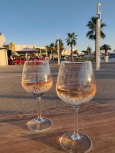 two wine glasses sitting on top of a wooden table at Clubber Naturiste Design in Cap d'Agde
