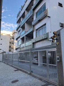 un edificio alto con una valla delante en Praia do Forte Apartamento, en Cabo Frío