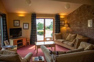 a living room with a couch and a tv at Churchlands in Bromyard