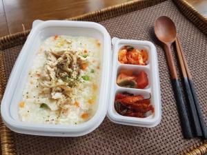 a lunch box with a container of food and a spoon at Arts Spa&Poolvilla in Jeju