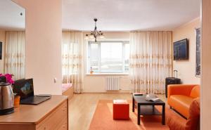 uma sala de estar com um sofá laranja e uma secretária em Hotel Impuls em Surgut