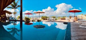 a swimming pool with chairs and umbrellas on a resort at Deco Stop Lodge in Luganville