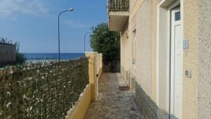 uma passagem ao lado de um edifício com uma cerca em Sunny Beach Home em Rometta Marea