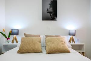 een slaapkamer met een wit bed en 2 lampen bij Mucura Hotel & Spa in Cartagena