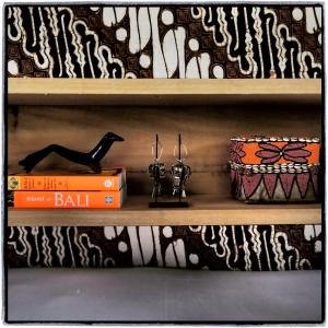 a shelf with books and a box and two glasses at Sanak Retreat Bali in Munduk