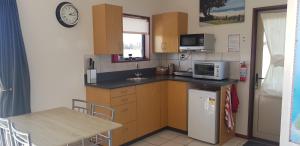 una pequeña cocina con fregadero y microondas en Bentleys Country Stay en Hawarden