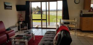 a living room with a couch and a large window at Bentleys Country Stay in Hawarden