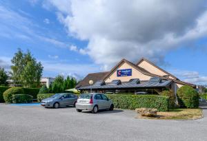 two cars parked in a parking lot in front of a building at Comfort Hotel Evreux in Évreux