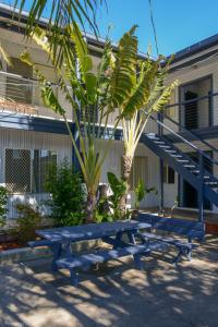 dos mesas de picnic azules frente a un edificio en Jamaica Holiday Units, en Forster