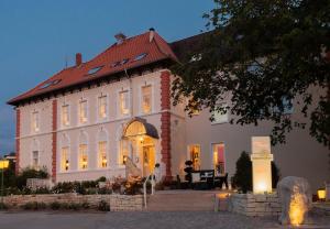 ein großes weißes Gebäude mit rotem Dach in der Unterkunft Parkhotel Bilm im Glück am Stadtrand Hannovers in Sehnde