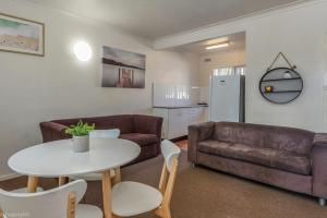 una sala de estar con un sofá y una mesa en Jamaica Holiday Units, en Forster