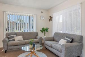 a living room filled with furniture and a window at Jamaica Holiday Units in Forster