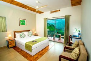 a bedroom with a bed and a living room at Mistletoe Homestay & Cafe in Munnar