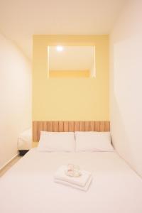 a white bed with a towel on top of it at LTL Guesthouse in Johor Bahru