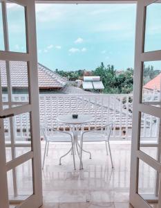 a white table and chairs on a balcony at Hikari Guesthouse in Seminyak