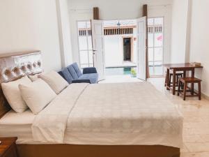 a bedroom with a large bed and a blue couch at Hikari Guesthouse in Seminyak