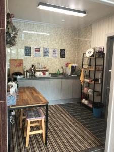 a kitchen with a wooden table and a counter at Us on Earth Guesthouse in Danyang