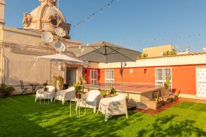 patio z białymi krzesłami, stołami i parasolami w obiekcie B&B Sparano Luxury Suites w mieście Bari