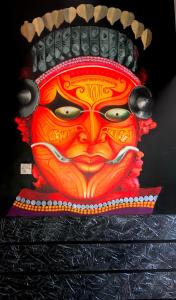 a painting of a face on a wall at Indian Art Villa in Varkala