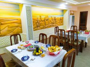 a dining room with two tables with plates of food at Hotel Shams in Bukhara