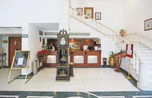 un orologio nel mezzo di una stanza con scale di Ashok Country Resort a Nuova Delhi