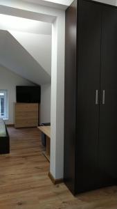 Habitación con armario negro y TV. en Самостоятелен етаж от къща за гости, en Haskovo
