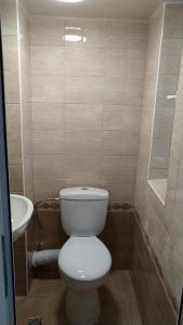 a bathroom with a white toilet and a sink at Самостоятелен етаж от къща за гости in Haskovo +5 photos