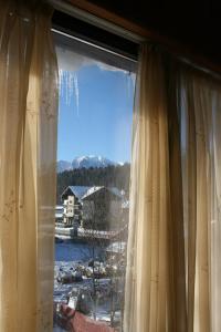 a window with a view of a snow covered mountain at Pensiunea Medieval in Predeal