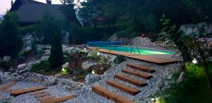 a backyard with a swimming pool and a rock garden at Holiday Home Katričnek in Bohinjska Bela