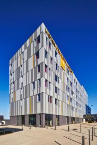 a tall gray building with colorful windows at Premiere Classe Clermont Ferrand Centre in Clermont-Ferrand