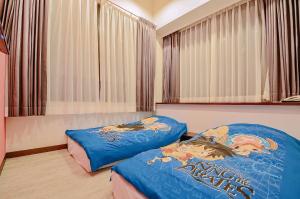 twee bedden in een kamer met ramen en gordijnen bij Calamari in Magong