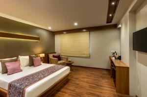 a hotel room with a bed and a desk at Hotel Delice in Bhilwara