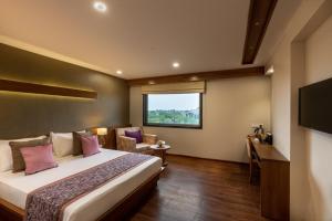 a hotel room with a bed and a window at Hotel Delice in Bhilwara